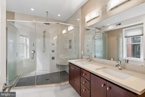 a bathroom with a double vanity sink mirror double shower and a