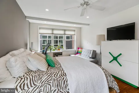 a bedroom with a bed a window and a flat screen tv