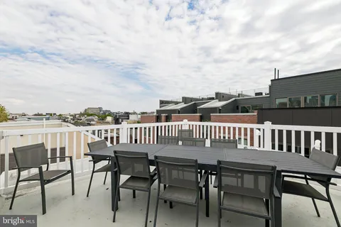 a view of a roof deck with table and chairs