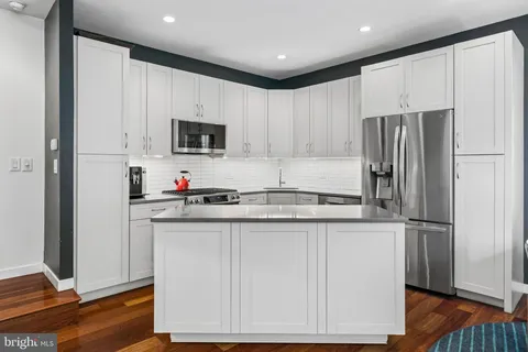 a kitchen with stainless steel appliances granite countertop a refrigerator sink and microwave