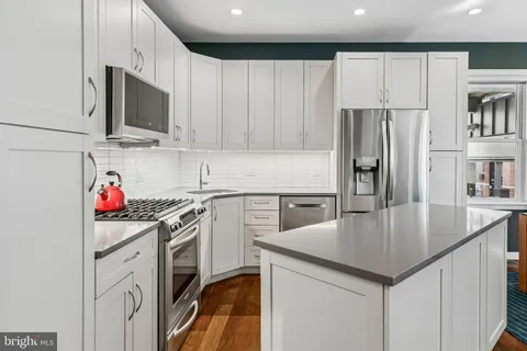 a kitchen with a sink a microwave a stove and refrigerator