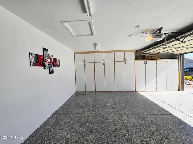 an empty room with wooden floor chandelier fan and windows