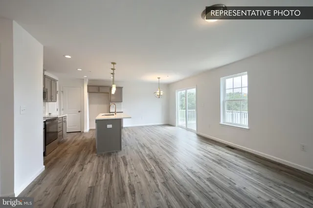 a view of kitchen with a sink wooden floor and windows