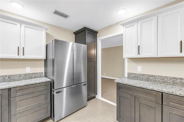 a kitchen with stainless steel appliances granite countertop a refrigerator stove and sink