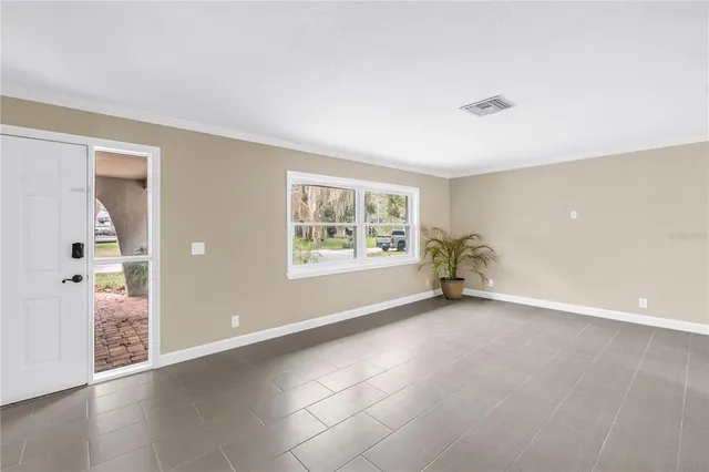 a view of a livingroom with a chandelier wooden floor and a kitchen