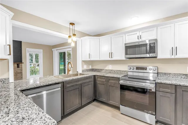 a kitchen with stainless steel appliances granite countertop a refrigerator and a sink