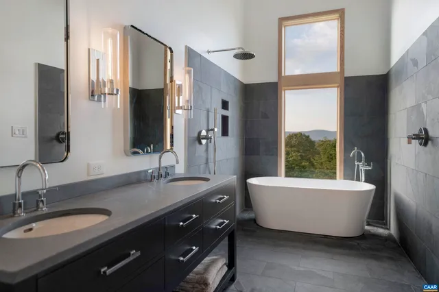 a bathroom with a double vanity sink tub and mirror