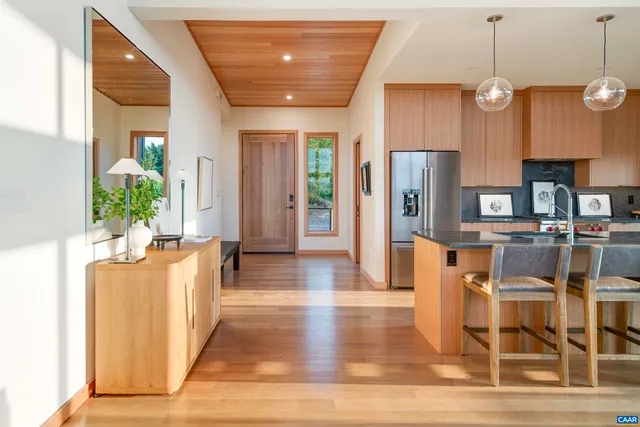 a living room with stainless steel appliances kitchen island granite countertop furniture and a wooden floor