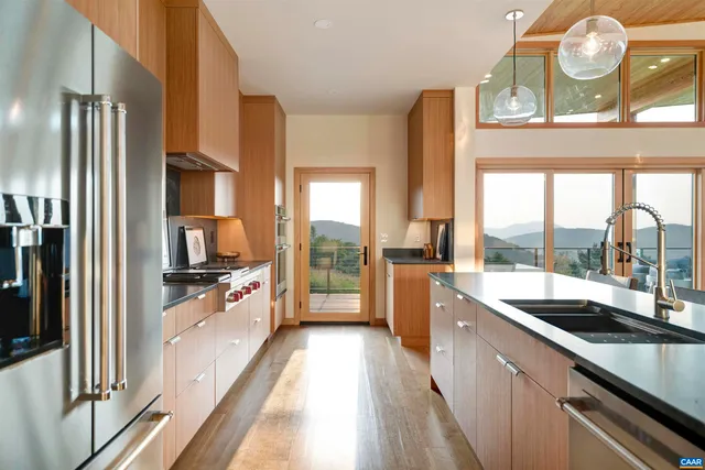 a large kitchen with a large window and stainless steel appliances
