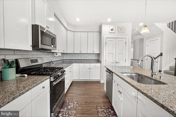 a kitchen with stainless steel appliances granite countertop a sink stove and cabinets