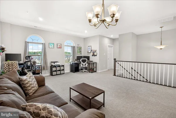 a living room with furniture a chandelier and a flat screen tv