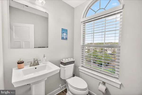 a bathroom with a sink a toilet and a window