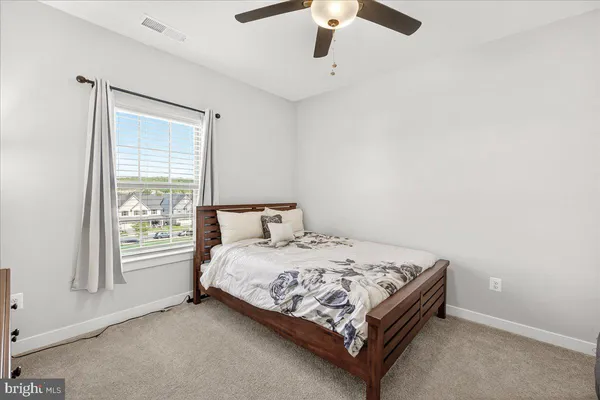 a bed sitting in a bedroom next to a window