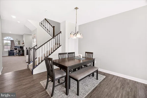 a dining room with furniture entryway and wooden floor