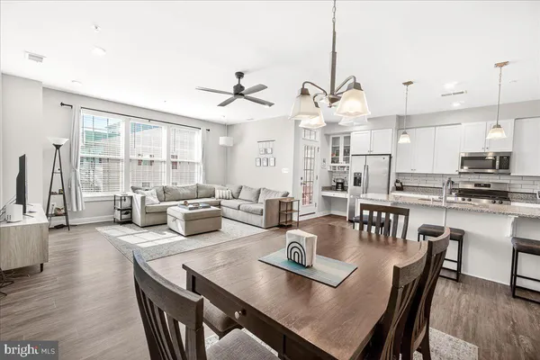 a view of a dining room and livingroom with furniture wooden floor carpet and a chandelier
