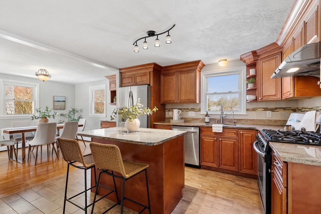 72 Grassland Street Lexington, MA 02421 - Photo 12 of 37 a kitchen with a dining table chairs cabinets and stainless steel appliances
