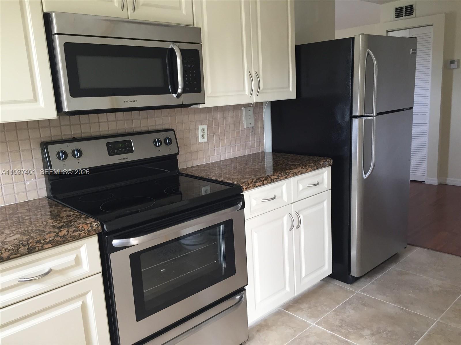 10441 Southwest 156th Court, Unit 421 Miami, FL 33196 - Photo 11 of 36 a kitchen with a stove microwave and refrigerator