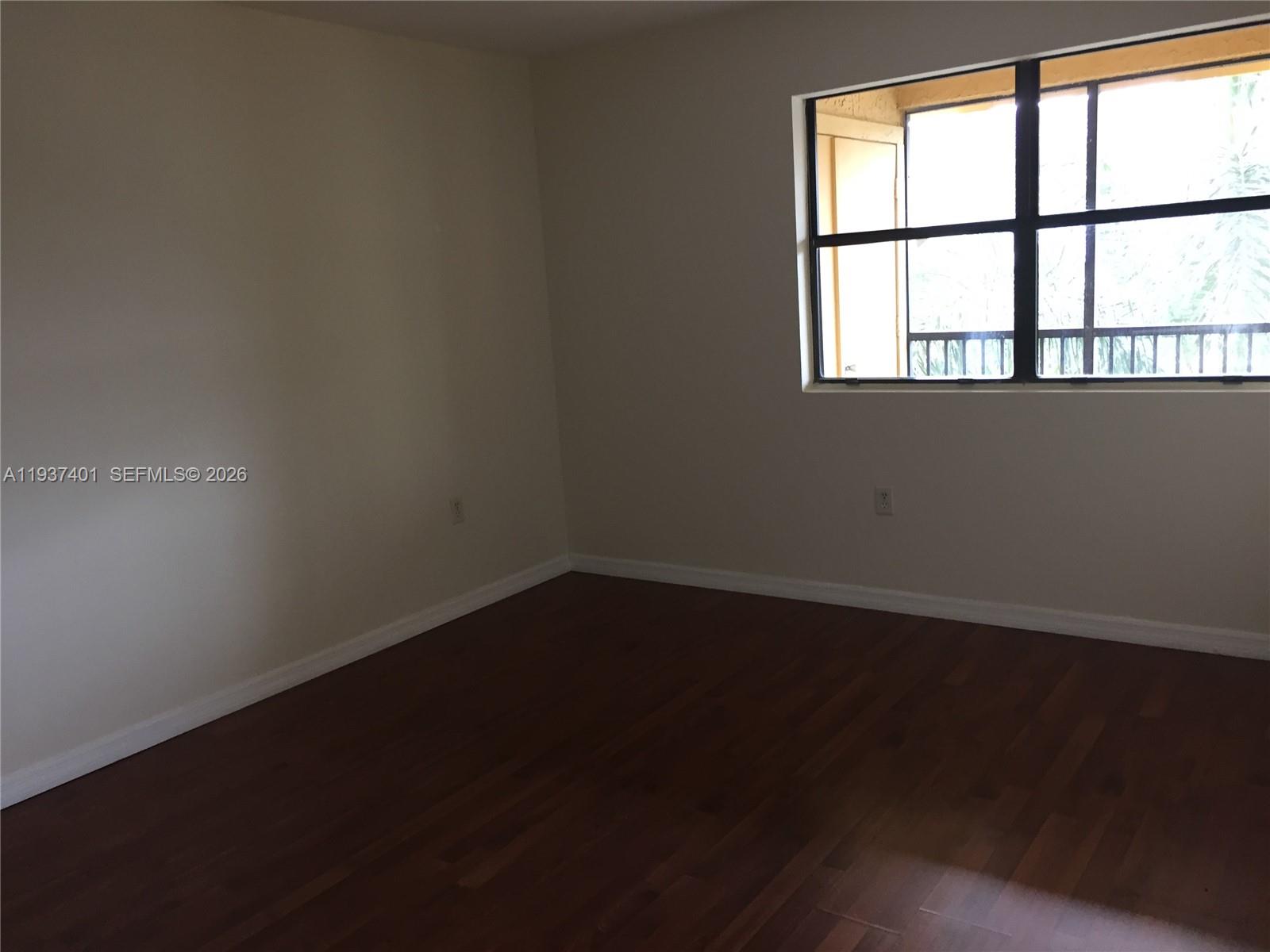 10441 Southwest 156th Court, Unit 421 Miami, FL 33196 - Photo 18 of 36 a view of an empty room with wooden floor and a window