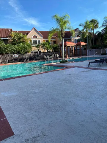a front view of a house with a yard and potted plants