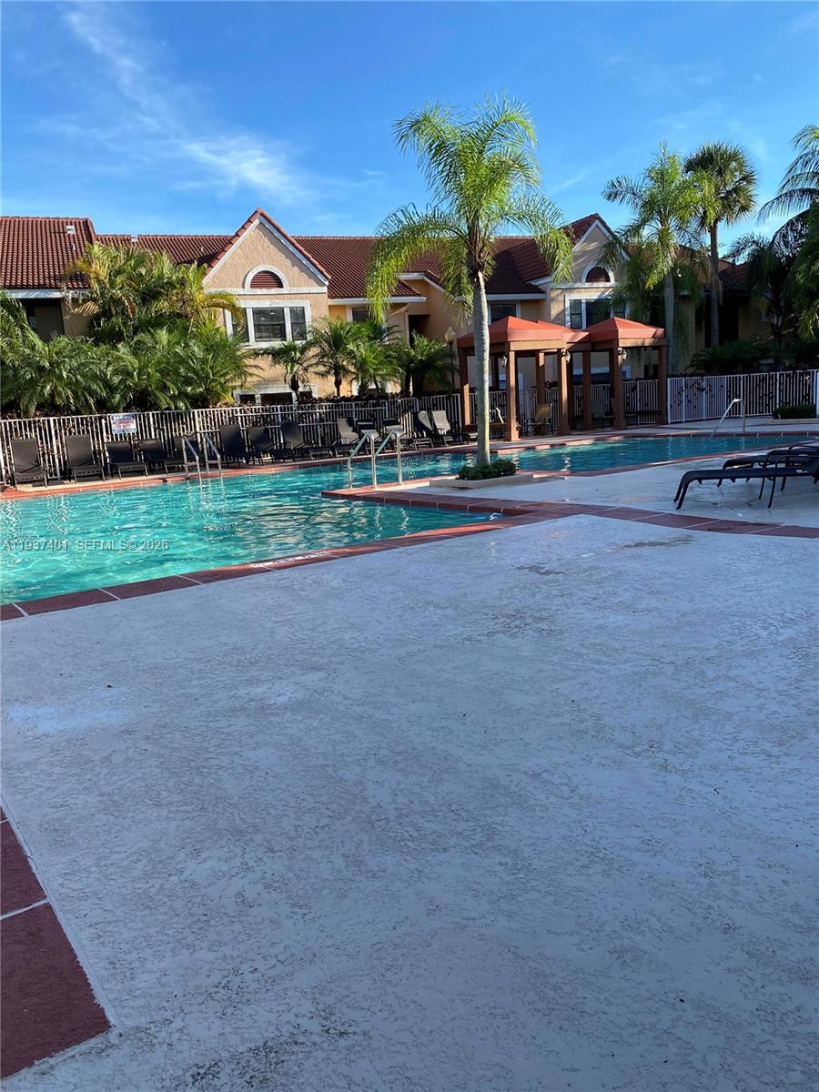 10441 Southwest 156th Court, Unit 421 Miami, FL 33196 - Photo 30 of 36 a front view of a house with a yard and potted plants