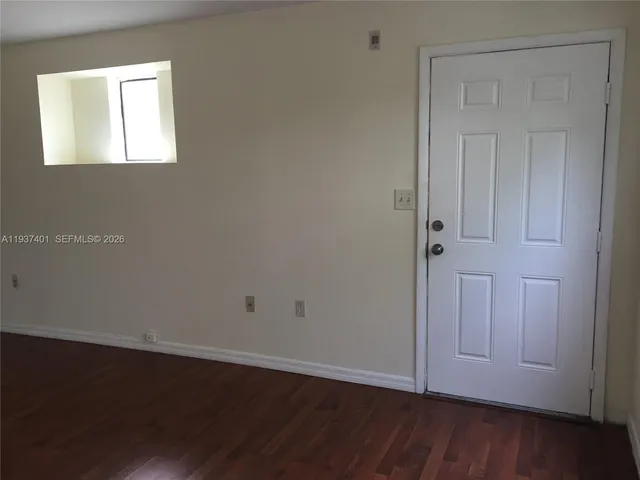 an empty room with wooden floor and closet area