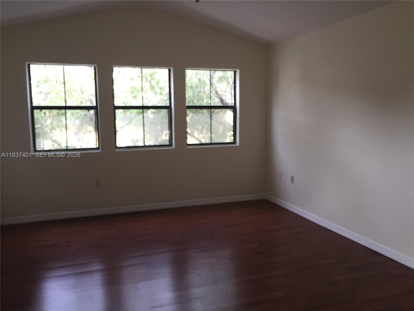 10441 Southwest 156th Court, Unit 421 Miami, FL 33196 - Photo 4 of 36 an empty room with wooden floor and windows