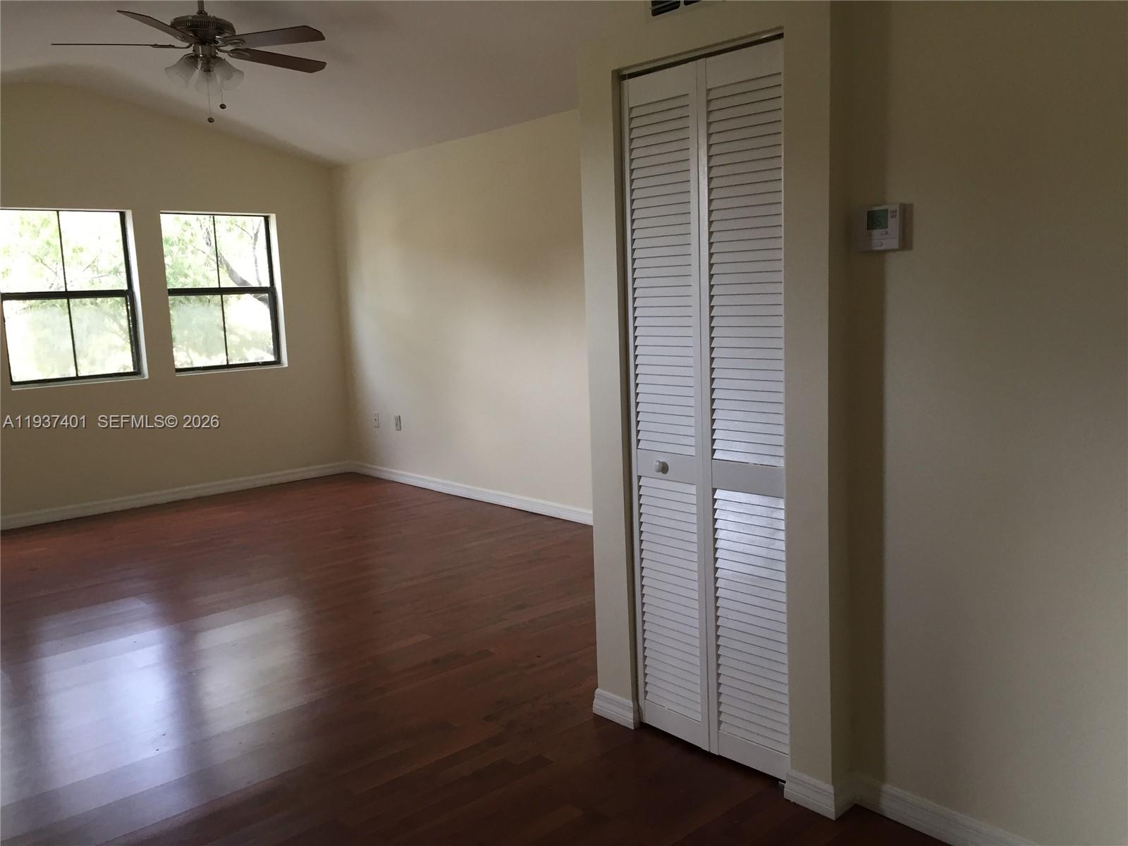10441 Southwest 156th Court, Unit 421 Miami, FL 33196 - Photo 6 of 36 an empty room with wooden floor closet and windows
