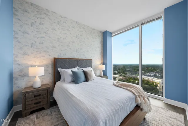 a bedroom with a bed and a large window