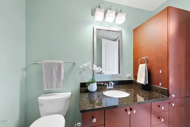 a bathroom with a granite countertop bathtub sink mirror and toilet