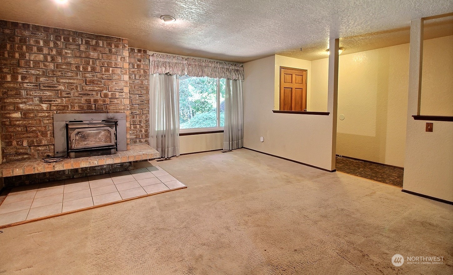 21123 West Richmond Road Bothell, WA 98021 - Photo 3 of 29 an empty room with windows fireplace and sink