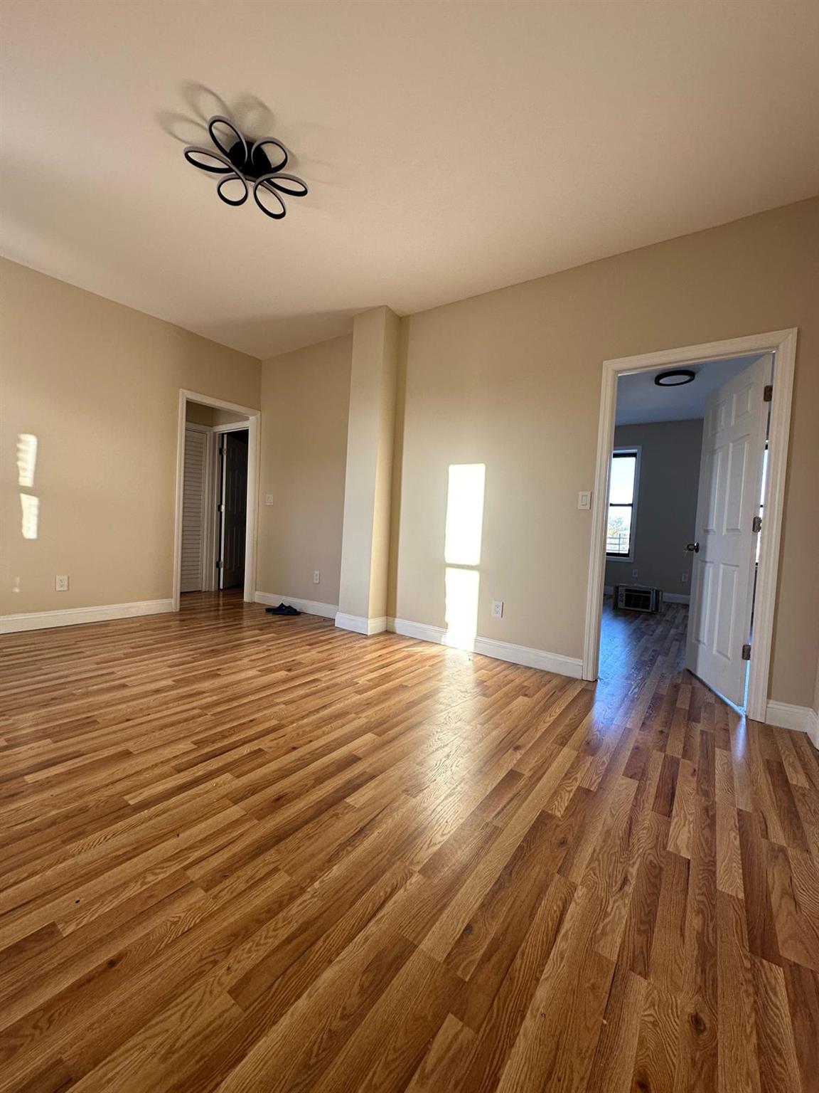 97-52 75th Street Queens, NY 11416 - Photo 2 of 9 a view of empty room with wooden floor and fan
