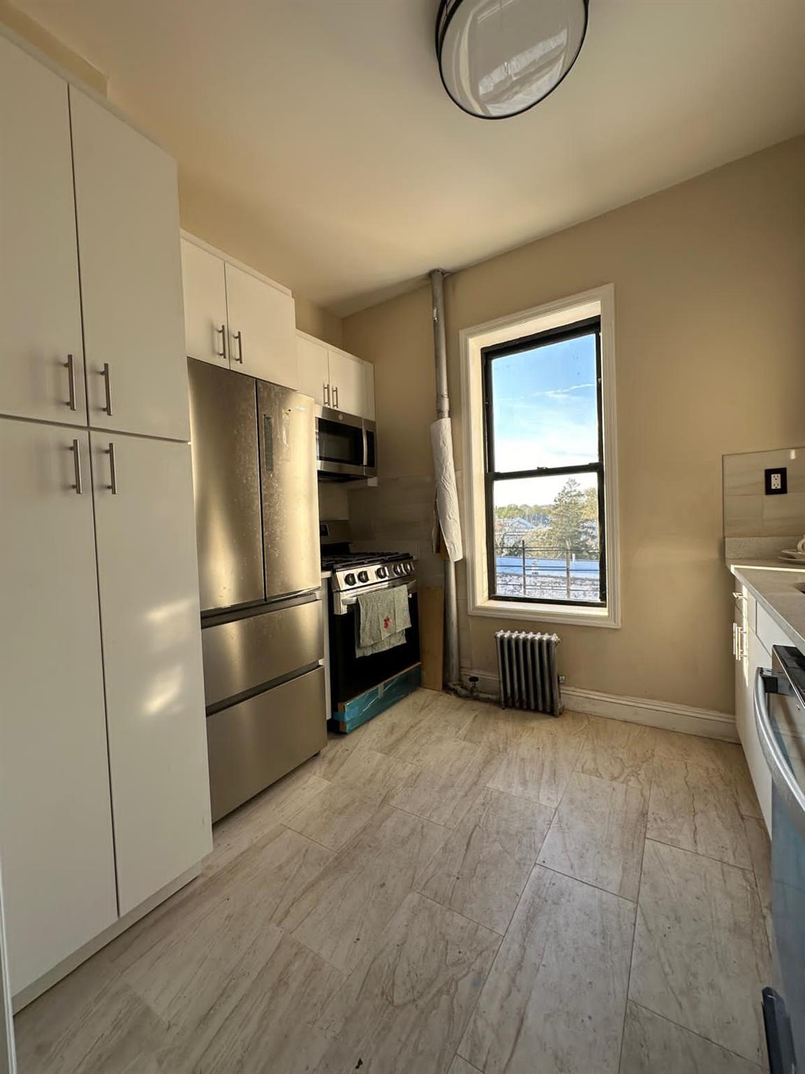 97-52 75th Street Queens, NY 11416 - Photo 3 of 9 a kitchen with a refrigerator a stove a washer and dryer