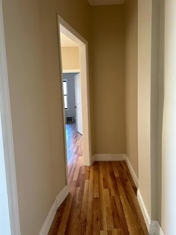a view of a room with wooden floor and a bathroom