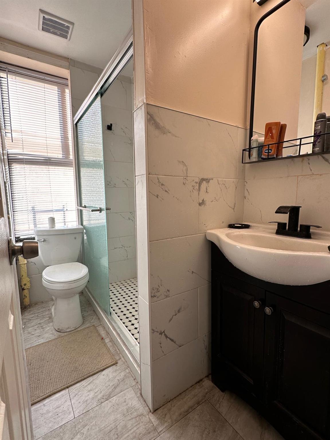97-52 75th Street Queens, NY 11416 - Photo 6 of 9 a bathroom with a toilet sink and mirror