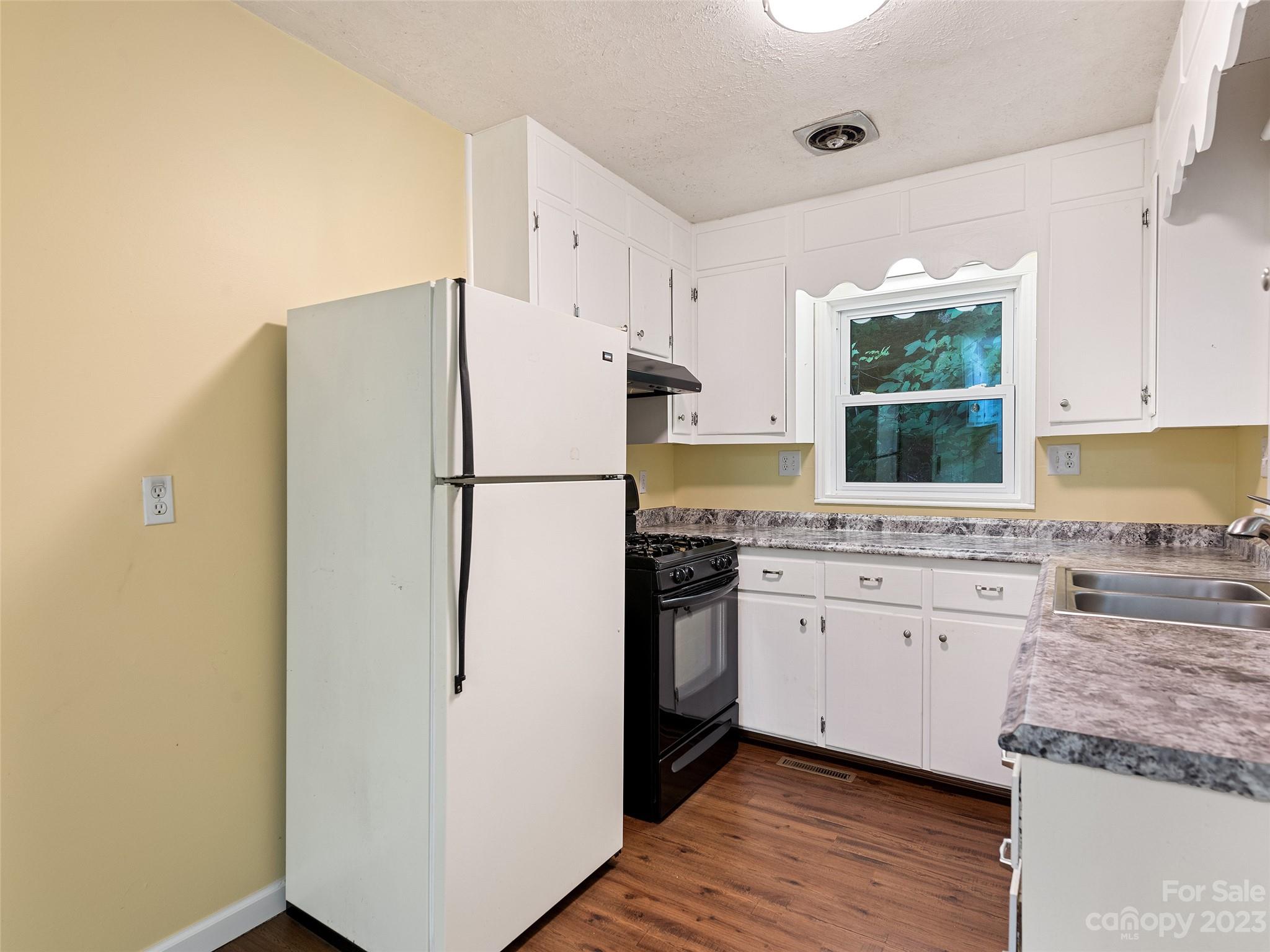 434 Red Bank Road Waynesville, NC 28786 - Photo 25 of 30 a kitchen with granite countertop a refrigerator sink stove and refrigerator