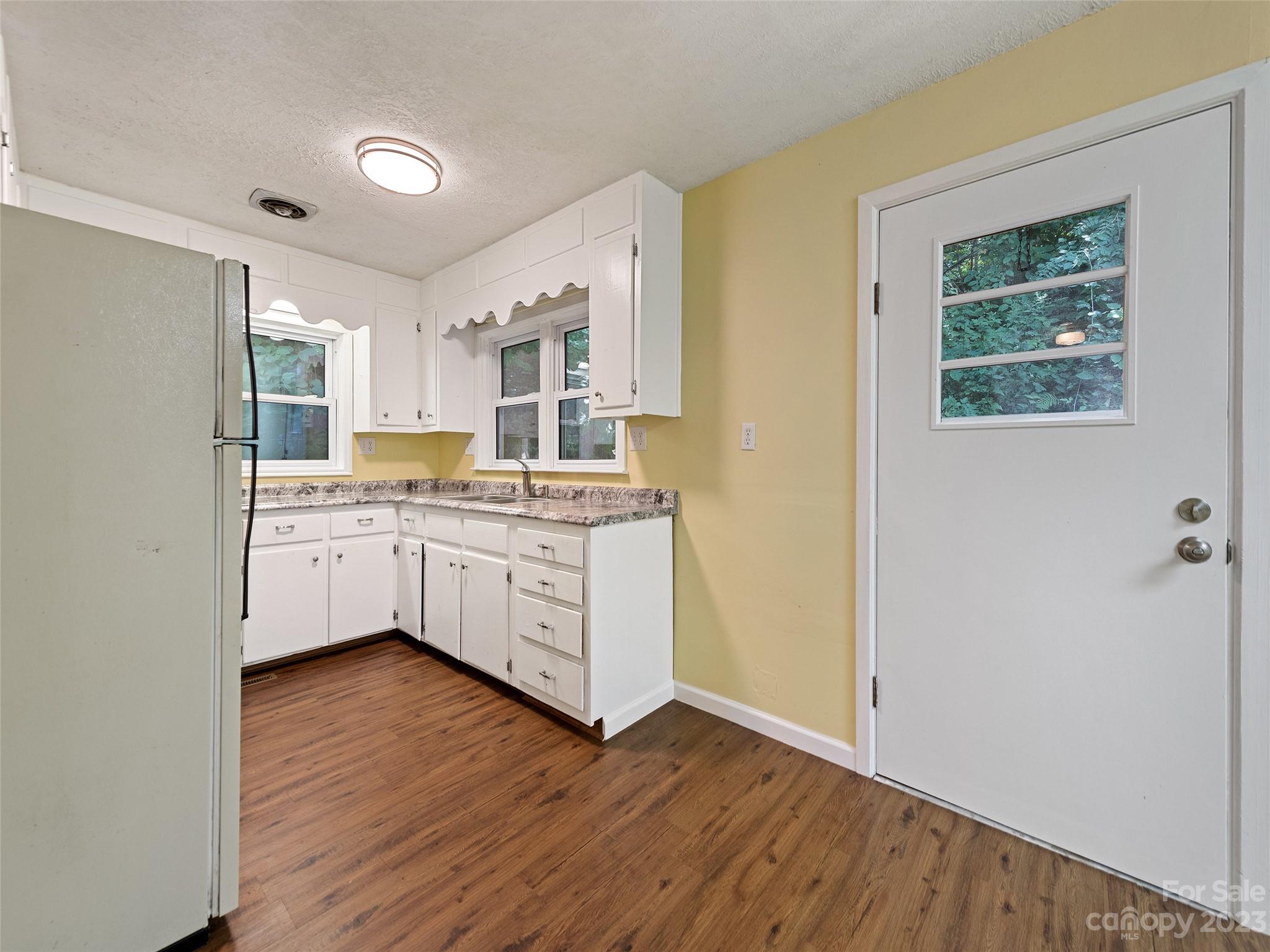434 Red Bank Road Waynesville, NC 28786 - Photo 29 of 30 a kitchen with wooden floors and white cabinets