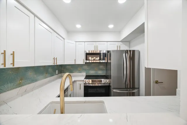a kitchen with a refrigerator sink and cabinets
