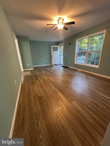 a view of a room with wooden floor and a window