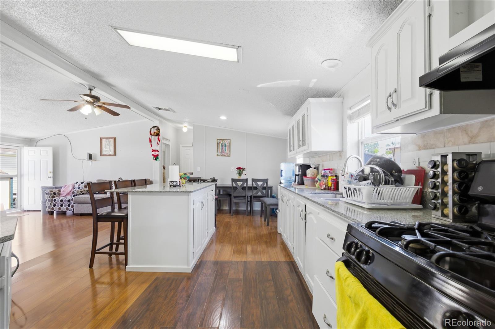 1724 Clark Street Aurora, CO 80011 - Photo 7 of 19 a kitchen with stove and wooden floor
