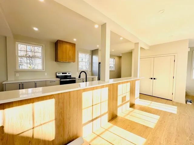 a large white kitchen with a large window