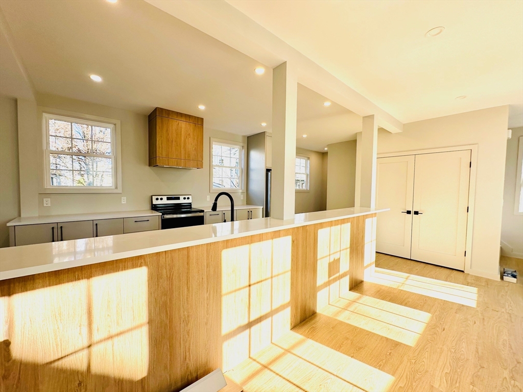 a large white kitchen with a large window