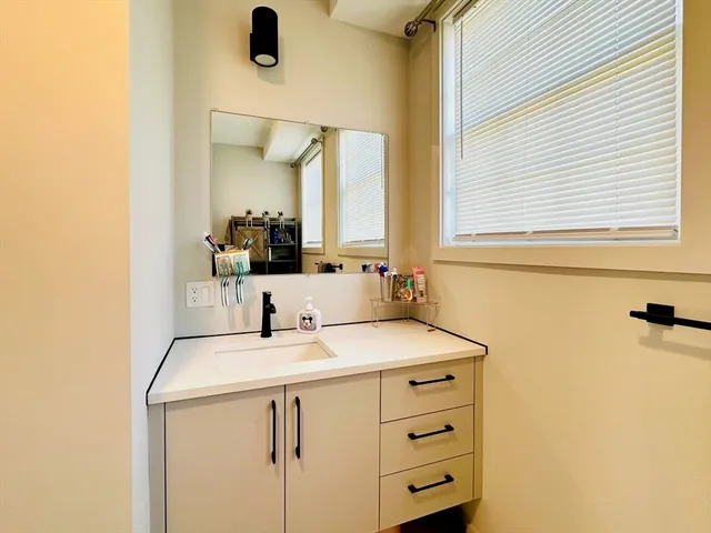 a bathroom with a sink vanity and a mirror
