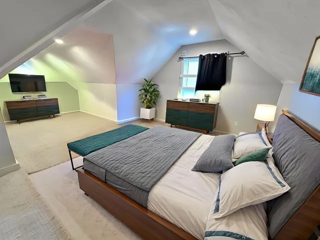 a bedroom with a large bed and a television