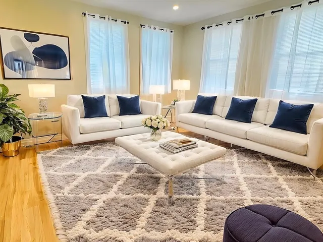 a living room with furniture and a painting on the wall