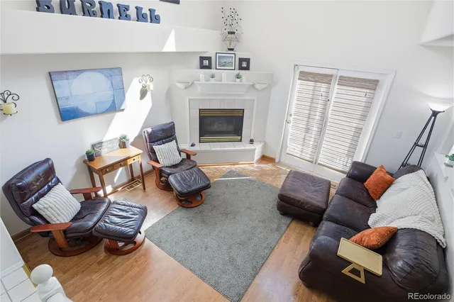 a living room with furniture floor to ceiling window and a fireplace