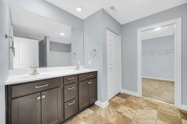a spacious bathroom with a granite countertop sink mirror and double