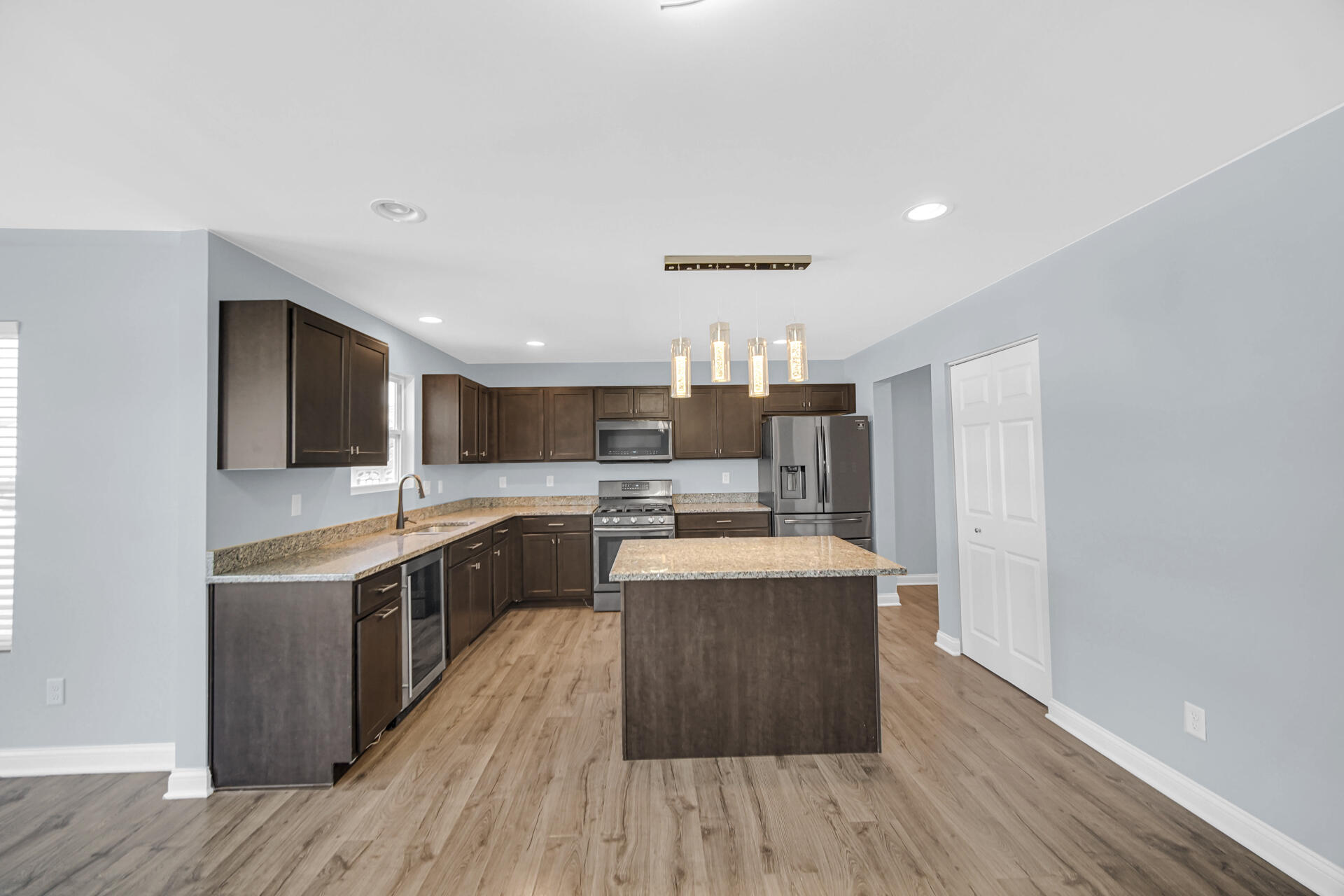 7428 East 120th Avenue Crown Point, IN 46307 - Photo 9 of 28 a large kitchen with stainless steel appliances kitchen island a large counter top and a wooden floors