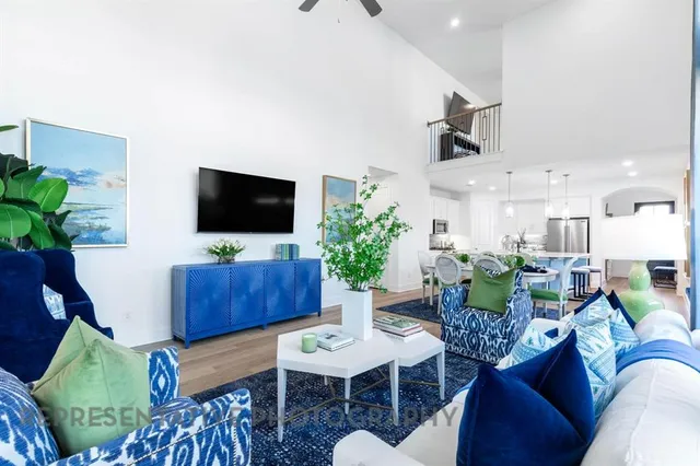 a living room with furniture a flat screen tv and a potted plant