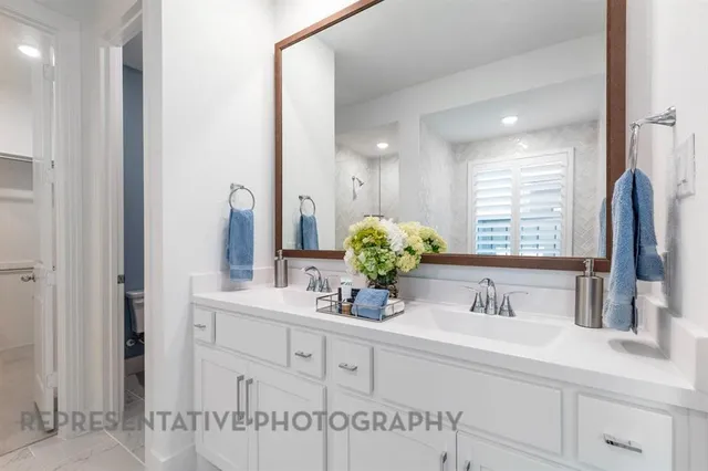 a bathroom with cabinets sink and a mirror