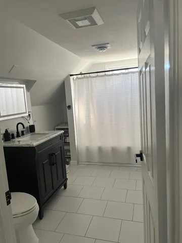 a view of bathroom with a toilet sink and mirror